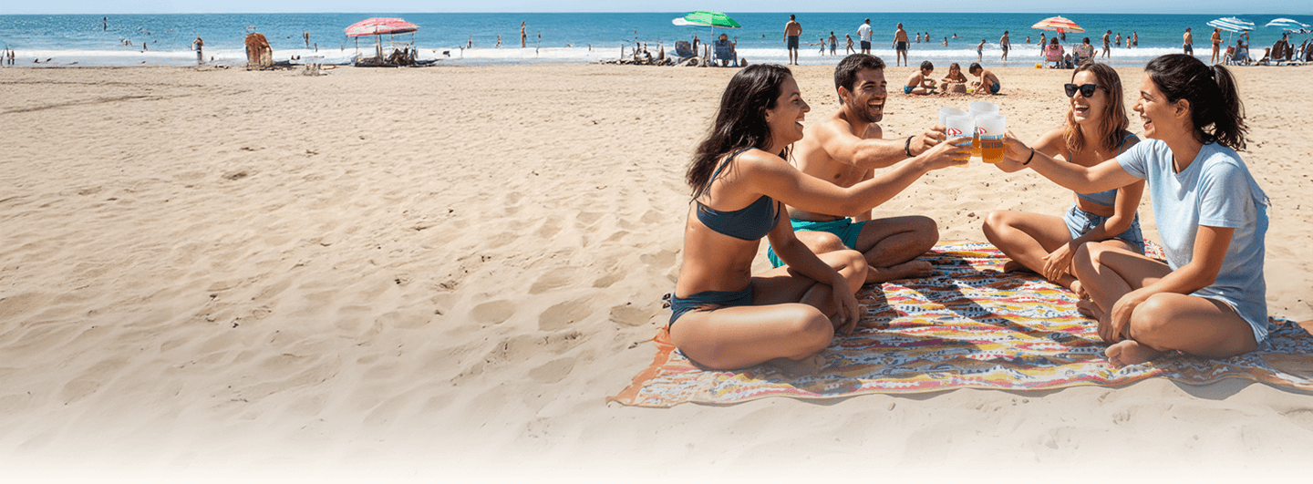 Amigos en la playa con ecovasos